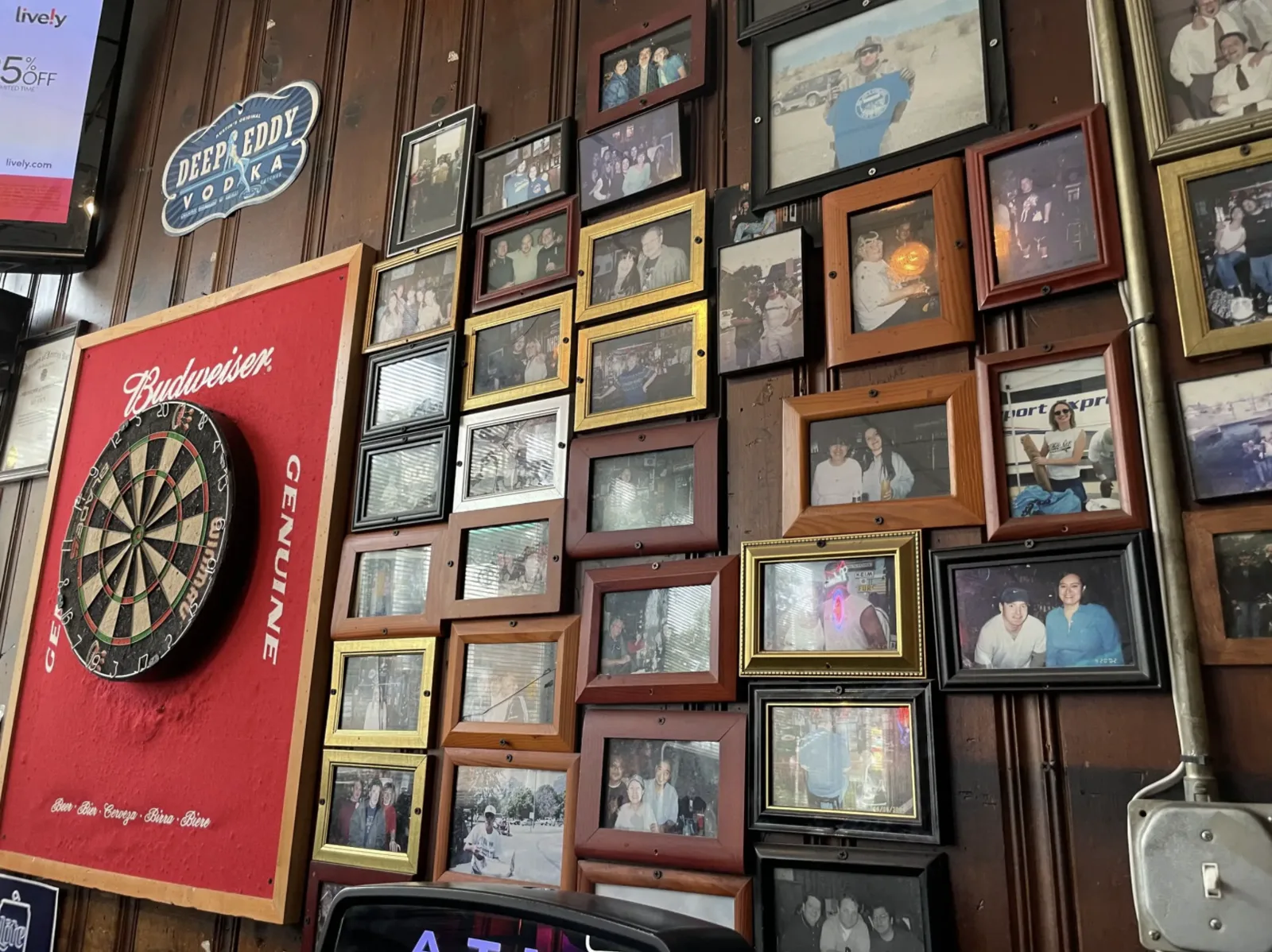 A Budweiser dartboard, Windy City Darters plaques, and wood paneling inside Big Joe's