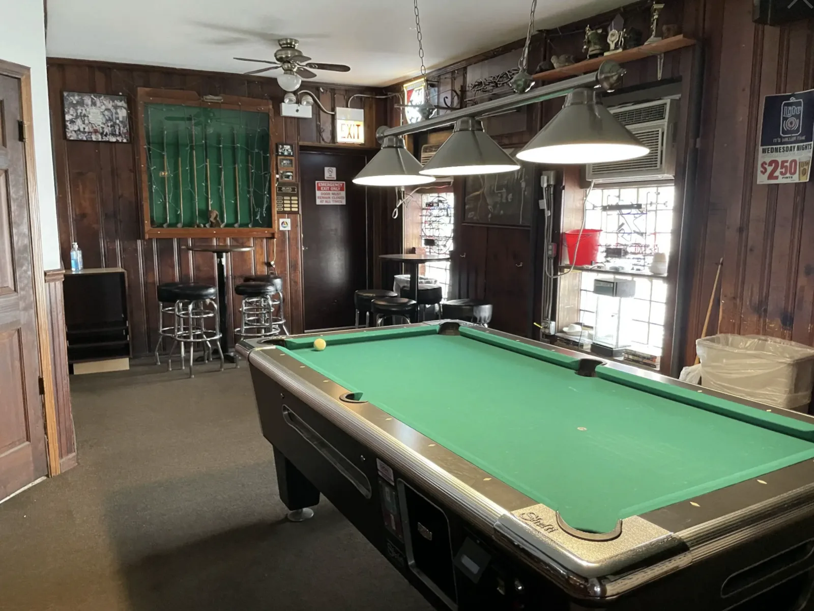 A Valley pool table, hanging lamps, and a cue case in the back room at Big Joe's