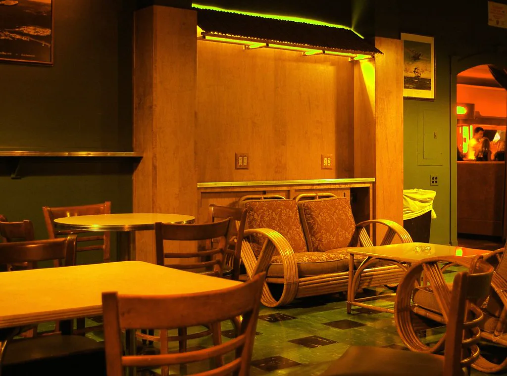 Rattan lounge chairs, checkered floor, and a green alcove inside the California Clipper