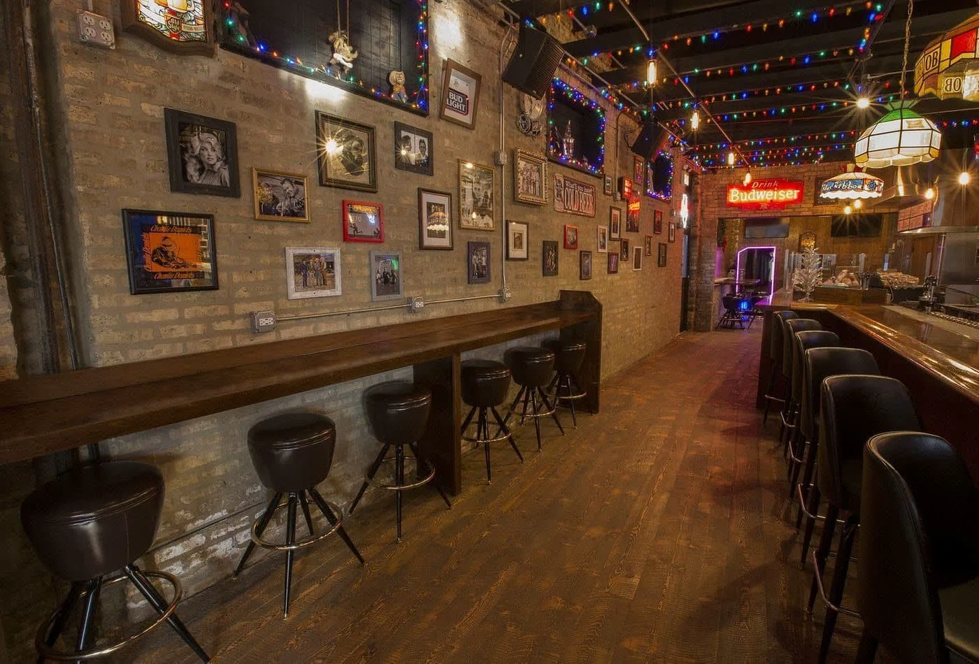 The memorabilia wall, string lights, and walkway inside Carol's Pub