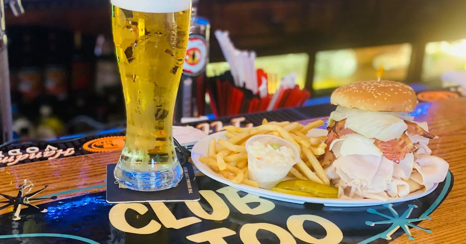 A pilsner and sandwich on the Club 81 Too bar, with CLUB TOO lettering on the rail
