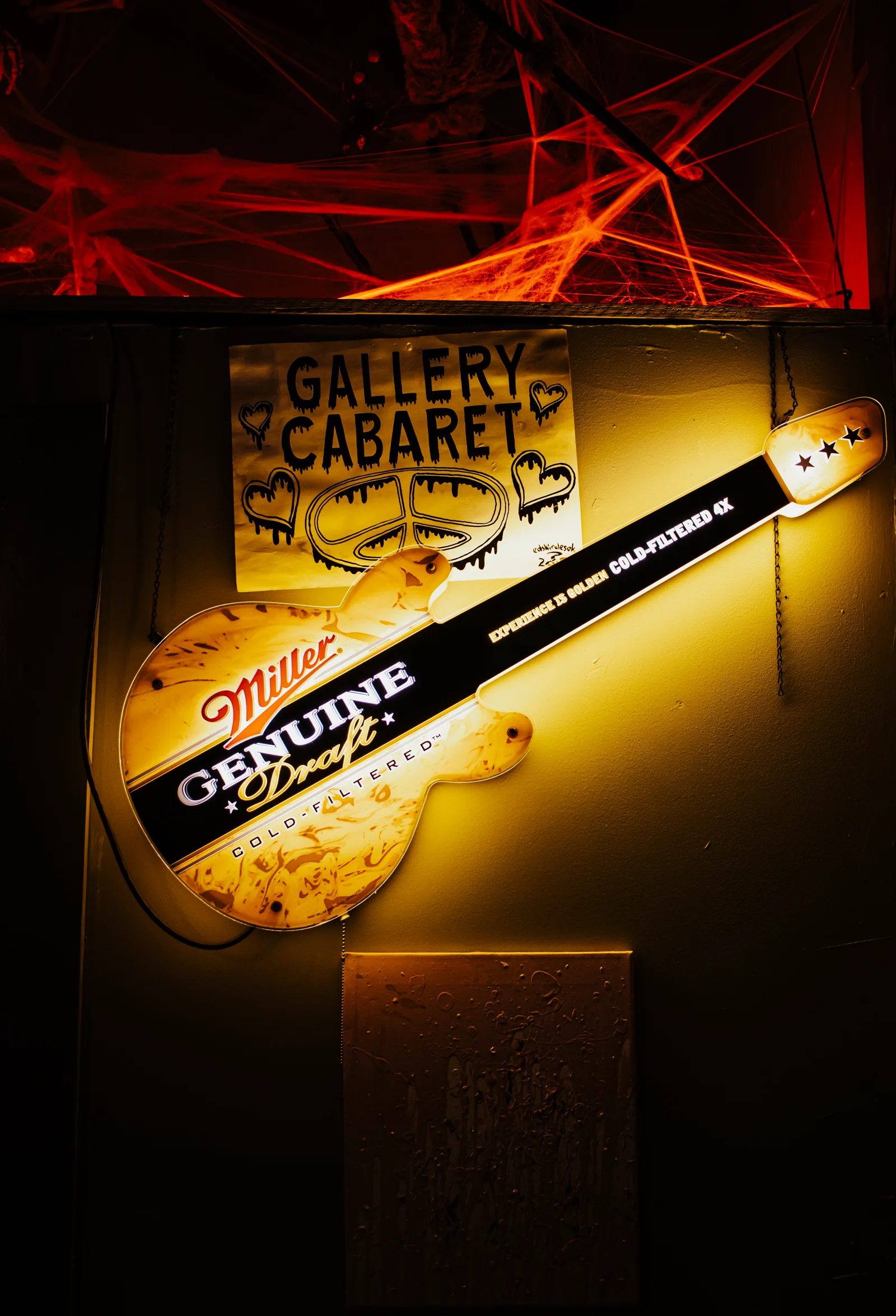 A hand-lettered Gallery Cabaret sign and Miller Genuine Draft guitar neon on the wall