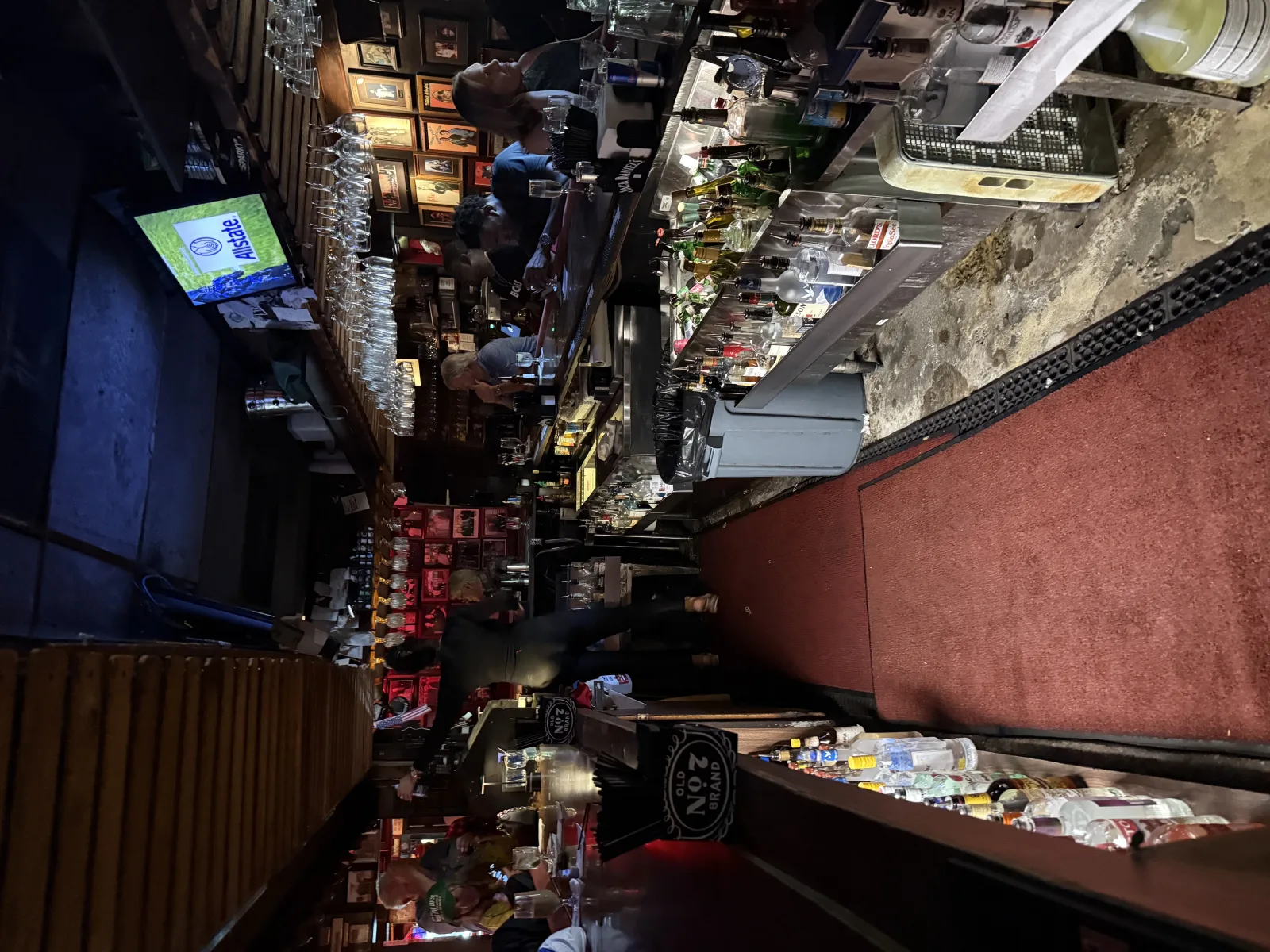 Behind the bar at Johnny's Hideaway: bottle well, hanging glasses, and regulars at the rail