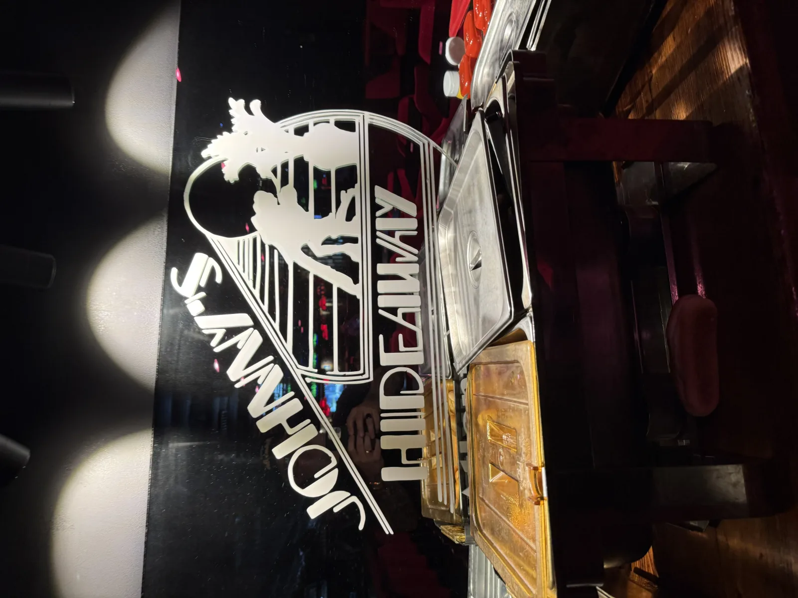 Johnny's Hideaway dancing-couple logo etched on glass behind the chafing-dish buffet