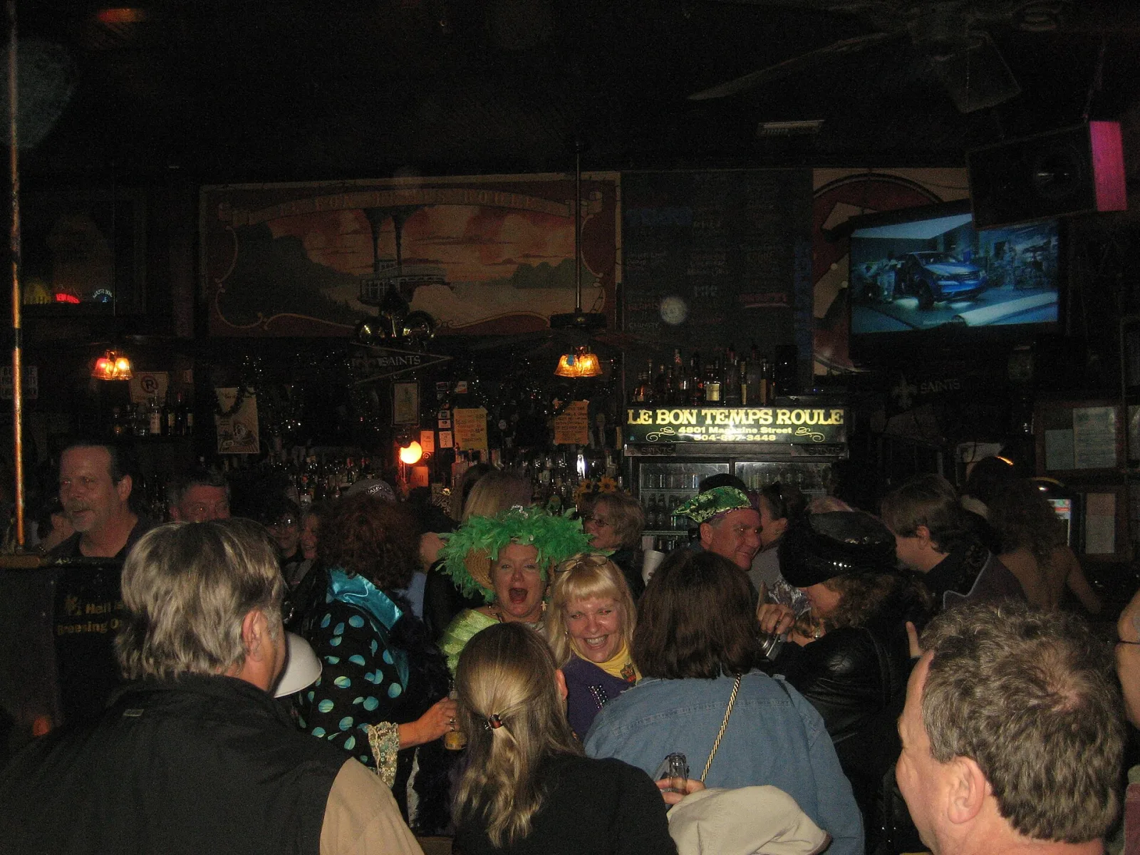 A crowded night inside Le Bon Temps Roule under the bar's TVs and signs