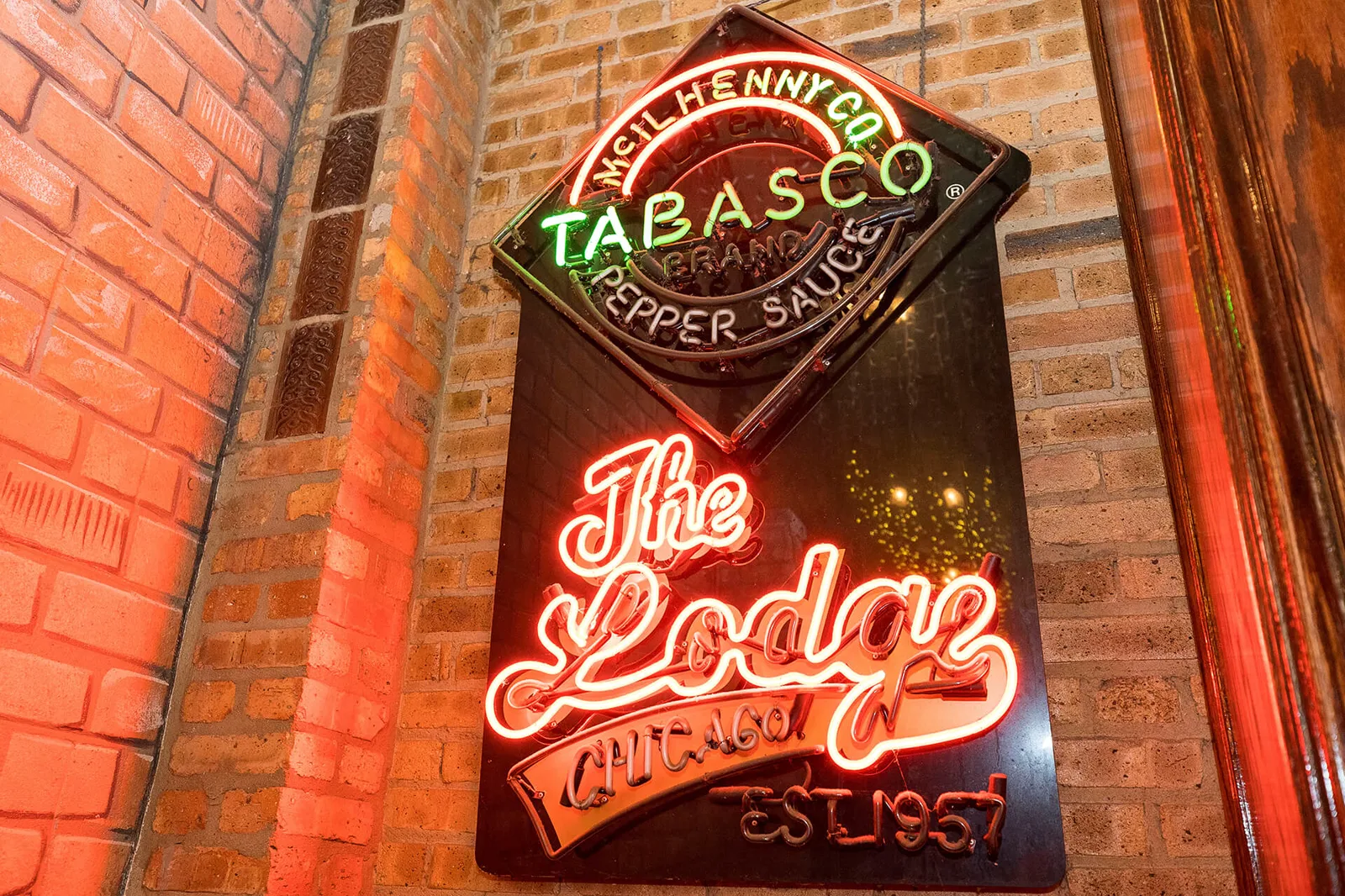 The red Lodge Chicago Est 1957 neon on a brick wall inside the tavern