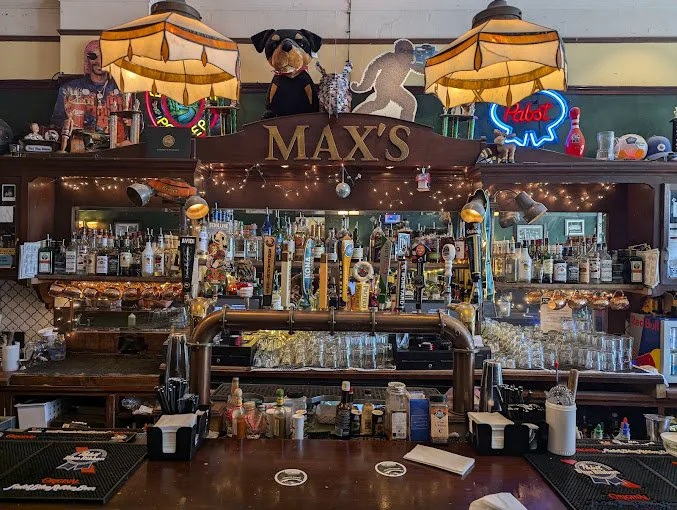The MAX'S gold header, Pabst neon, taps, and cluttered back bar inside Max's Tavern