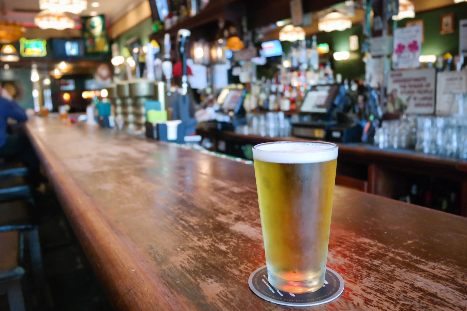 A Pabst Blue Ribbon pint on the worn wooden rail at Max's Tavern