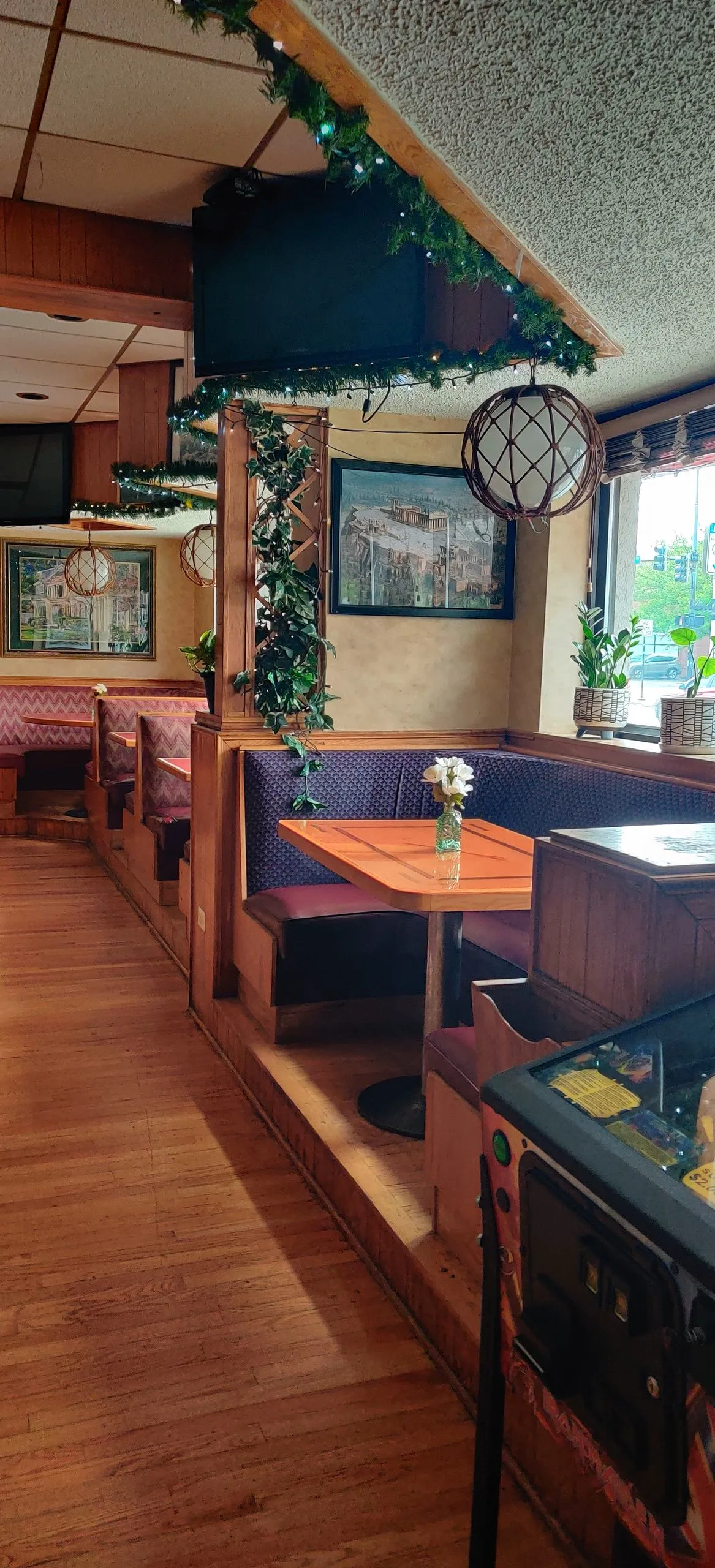 Empty maroon booths, pinball, and a street window in the Oakwood 83 dining room