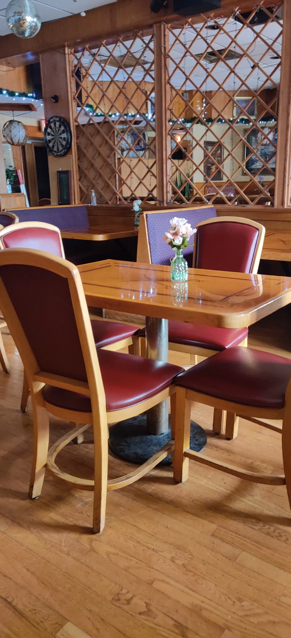 Empty tables, a dartboard, and a disco ball in the Oakwood 83 back room