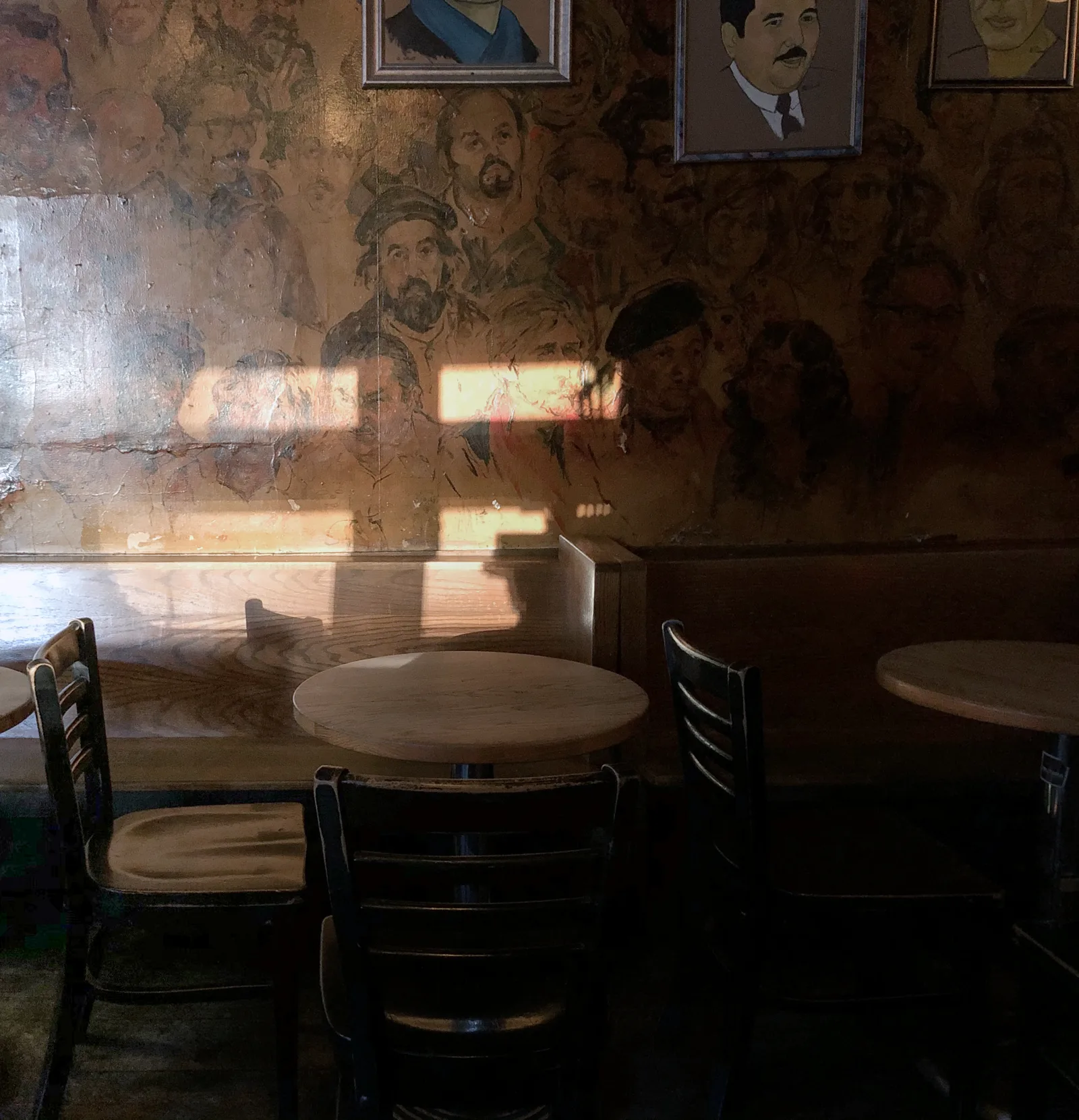 The interior of Old Town Ale House, with portraits on the walls and a crowded barroom