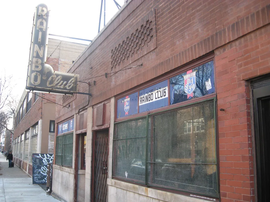 The Rainbo Club brick storefront, window lettering, and vertical neon on Damen Avenue